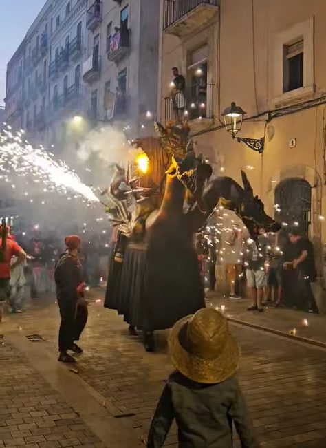 Cabrot del Vendrell, una bestia de fuego con múltiples cabezas, en acción en una calle estrecha durante el Correfoc en Tarragona. La figura lanza chispas mientras público y Diables observan.
