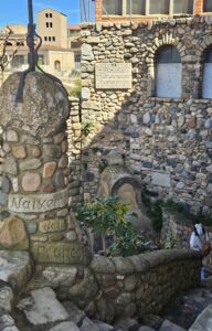 Detalle de una fuente antigua de piedra con musgo y elementos de mampostería en el pueblo de L'espluga de Francolí, Montañas de Prades. Rincón histórico y arquitectura tradicional de la Sierra de Prades, Cataluña.