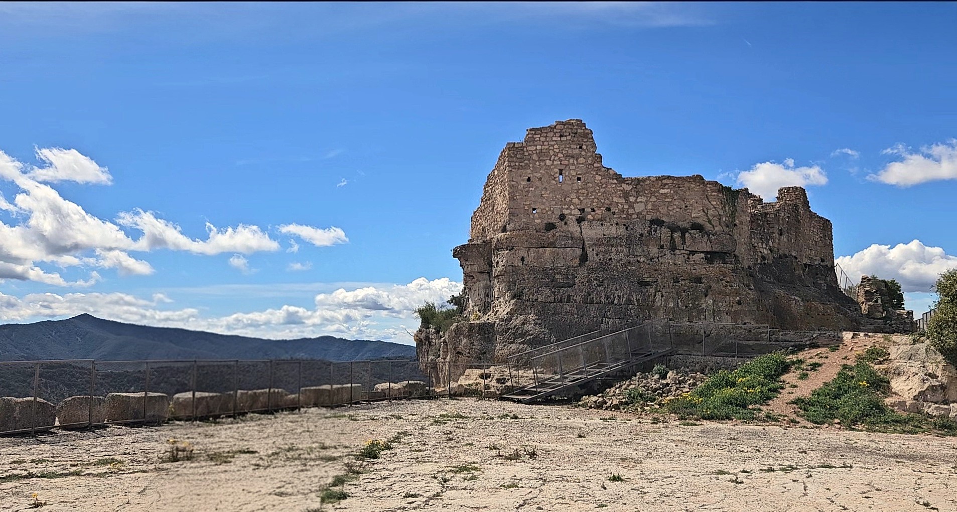 Restos de la torre en la cima de un acantilado al atardecer, mostrando su posición estratégica como antigua fortaleza inexpugnable.
