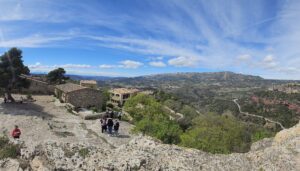 Vista panorámica del pueblo medieval de Siurana y su entorno natural. Muestra las casas de piedra y el vasto paisaje de las Montañas de Prades en Cataluña.