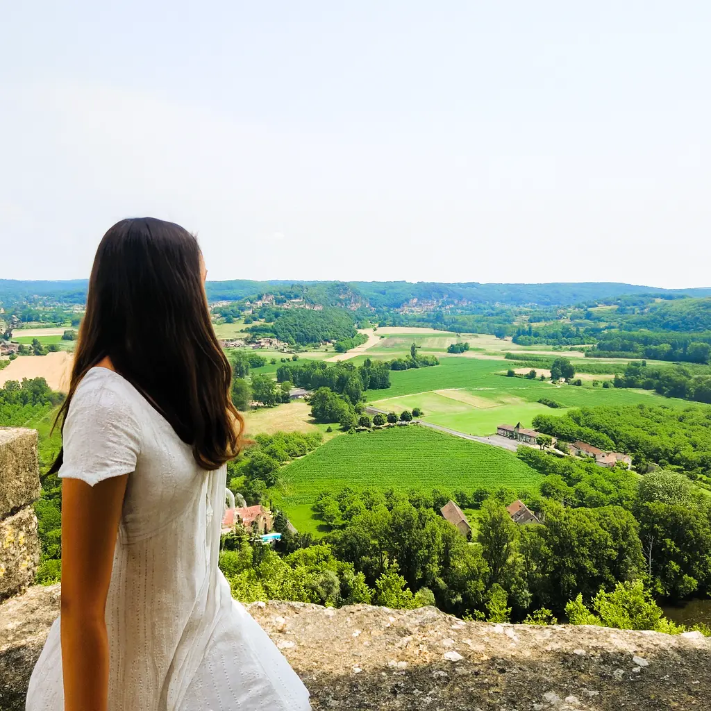 contemplando un extenso valle verde desde un mirador de piedra. Representación visual de un punto de respiro y la tranquilidad de viajar sin sobrecarga sensorial.