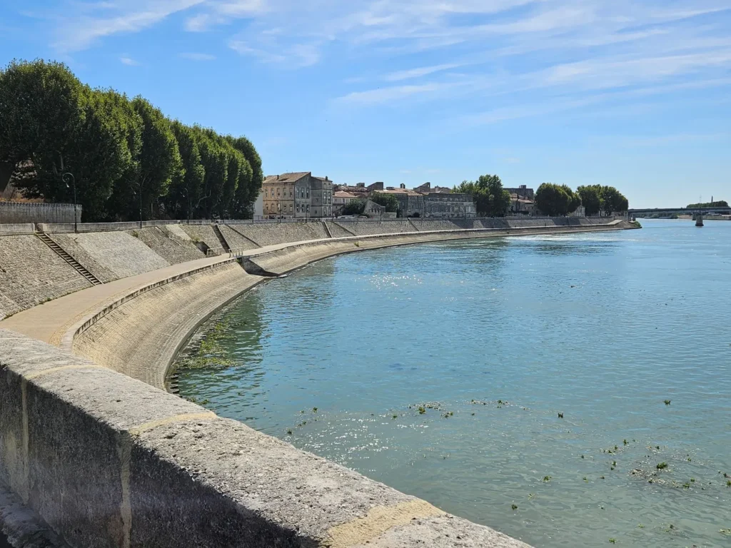 Vista panorámica del río Ródano en Arlés (Provenza) con un malecón curvo y edificios históricos. Ubicación inspiradora para las obras de Vincent van Gogh.
