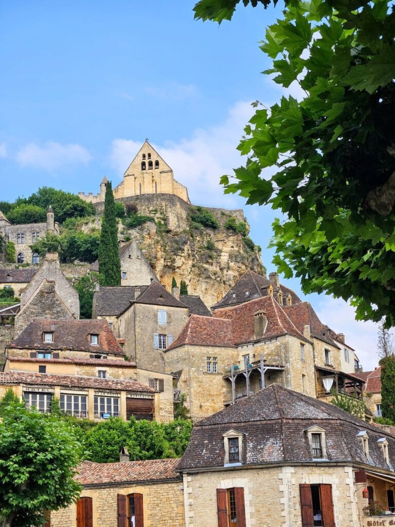 Vista de un pueblo medieval fortificado en una colina del Périgord Noir, con un castillo o iglesia en la cima. Es una locación recurrente para filmes históricos.