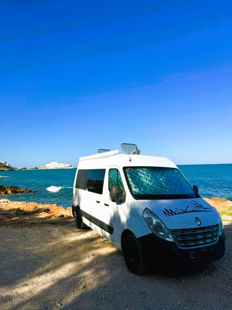 Furgoneta camper aparcada en un mirador de montaña sobre un valle profundo lista para el eclipse 2026.